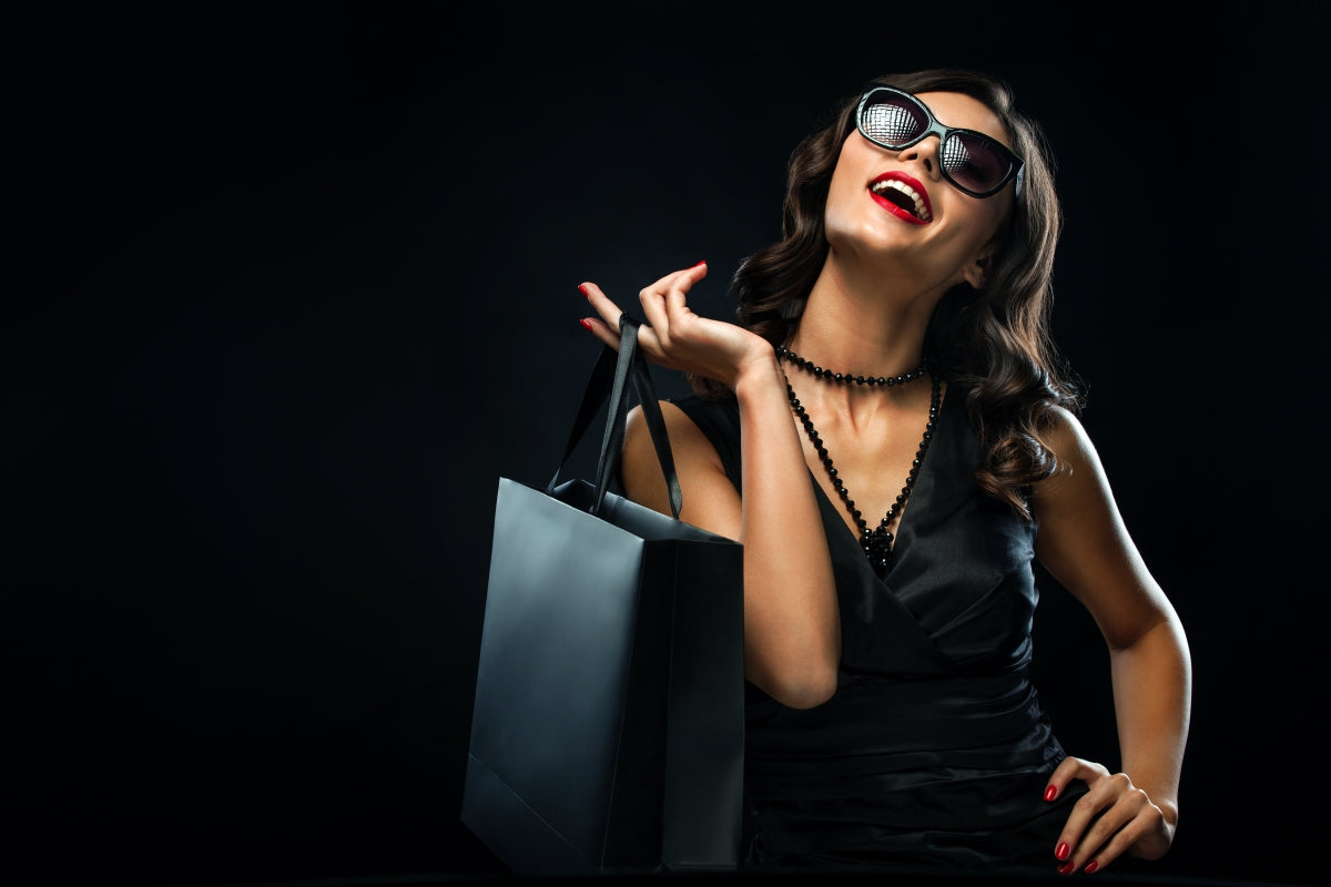 Black Friday sales concept. Shopping woman holding gray bag isolated on dark background during holiday